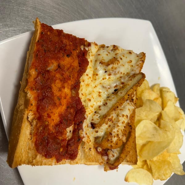 A chicken parmesan sandwich with marinara sauce and melted cheese, served with potato chips.